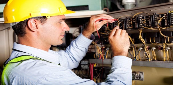 male electrician testing industrial machine